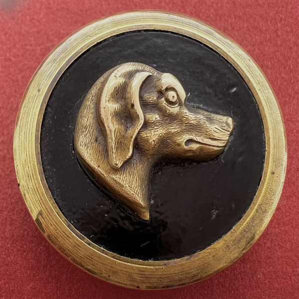 Brass dog head over leather set in brass button.