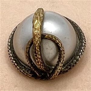 Snake entwined around pearlized glass dome mounted in metal button.