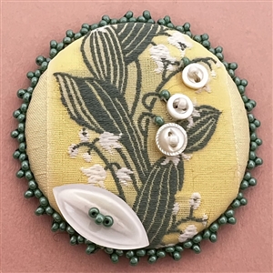 “Lily of the Valley" fabric studio button by Ann Howe on original card.