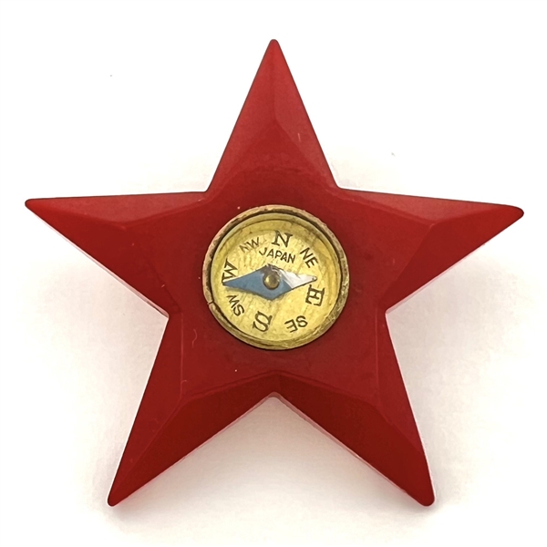 Red Bakelite button of realistic star with compass center.