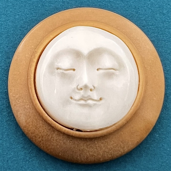 Studio button by Bob Benson of moon face.