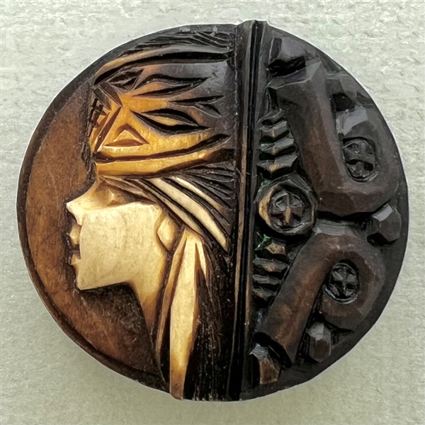 Wood button of a persons head in a hat.