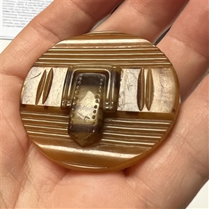 Horn (?) button of a belt and buckle.