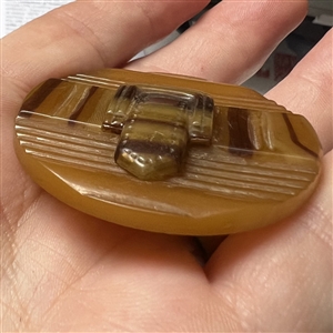 Horn (?) button of a belt and buckle.