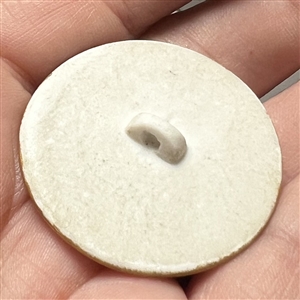 Painted porcelain button of a cherub playing a violin. 