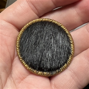 Animal fur with brass rim and tin back button.