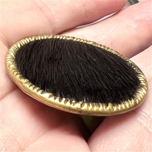 Animal fur with brass rim and tin back button.