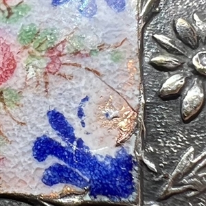 White metal button with flowers, enamel plaquette and paste border.