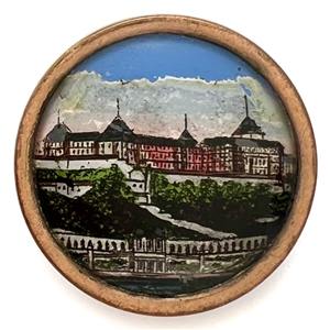 Reverse painted under glass button of an architectural scene of a large building.
