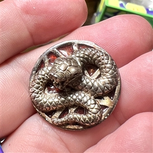 Sculptural gilded silver button of a snake with enamel background.