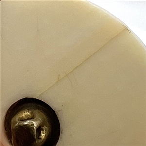 Carved natural material button of an Asian warrior.