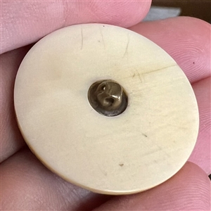 Carved natural material button of an Asian warrior.