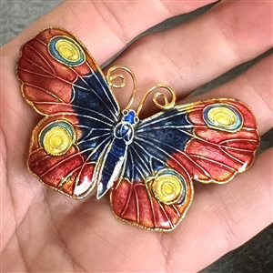 Cold enamel button of a realistic butterfly.
