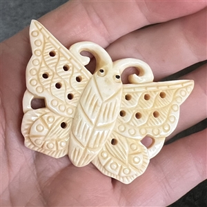 Carved natural material button of a realistic butterfly.