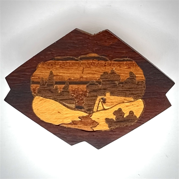 Marquetry wood button of a cabin or a smoking volcano.