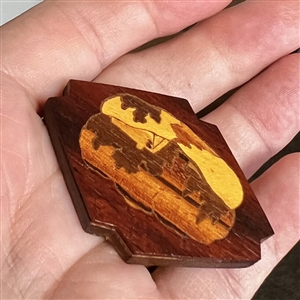 Marquetry wood button of a cabin or a smoking volcano.