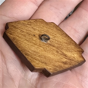 Marquetry wood button of a cabin or a smoking volcano.