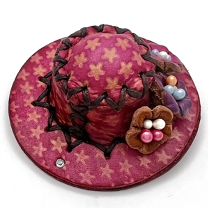 Leather button of a hat with flowers.