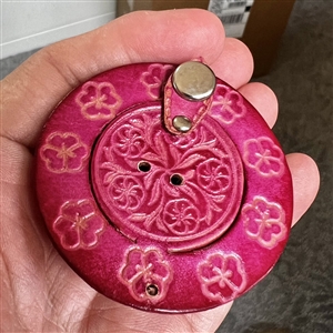 Leather button of a hat with flowers.