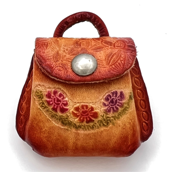 Leather button of a purse that opens.