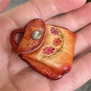 Leather button of a purse that opens.
