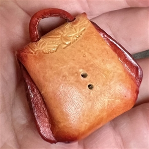 Leather button of a purse that opens.