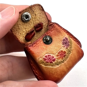 Leather button of a purse that opens.