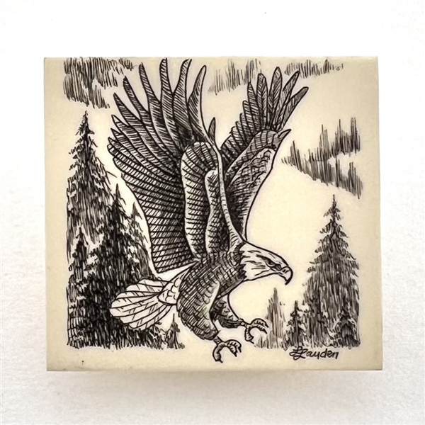 Scrimshaw on plastic of a flying eagle by L. Layden.
