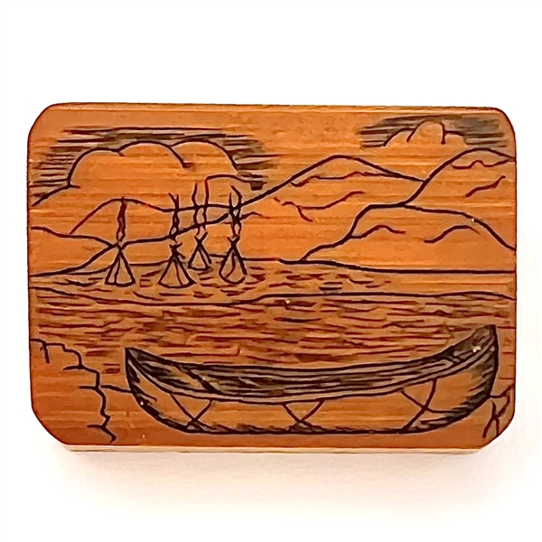 Wood studio pyrography button of a canoe and water scene.