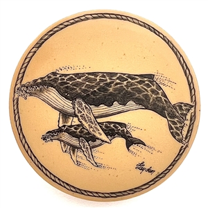 Scrimshaw on plastic of a mother whale and her calf by L. Layden.