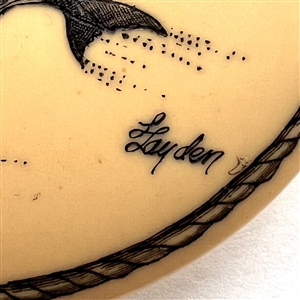 Scrimshaw on plastic of a mother whale and her calf by L. Layden.