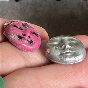 Two fimo sun and moon studio buttons.