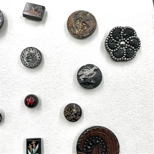 Card of 25 black glass buttons. 