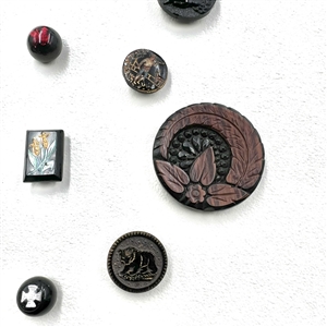 Card of 25 black glass buttons. 