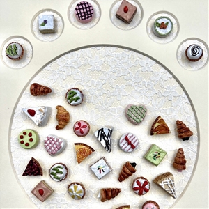 Framed card of 39 molded plastic buttons of pastries and deserts.
