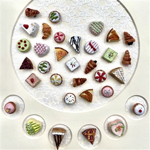 Framed card of 39 molded plastic buttons of pastries and deserts.
