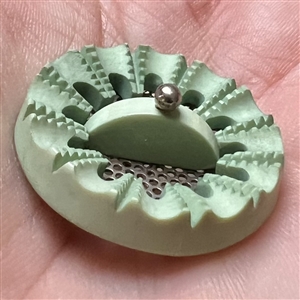 Screen back sculptural casein button with pin shank.