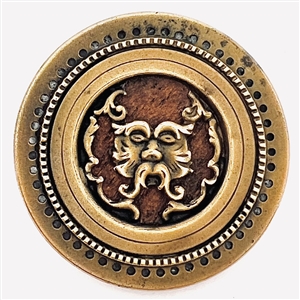 Brass Greenman button with a wood background.