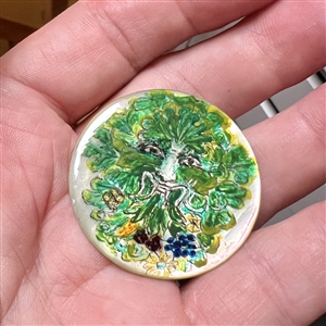 Painted pearl studio button of a Greenman.