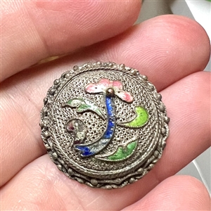 Silvered copper Asian button of an enameled flower.