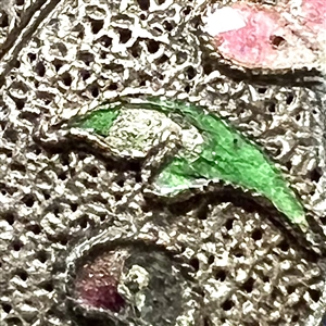 Silvered copper Asian button of an enameled flower.