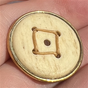 An 18th c. Death's head button on natural material.