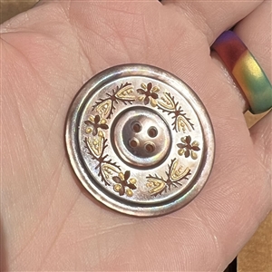 A 19th c. 4-hole pearl button of incised and pierced plant life.