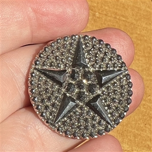 A 19th c. black glass button of a star with silver luster.