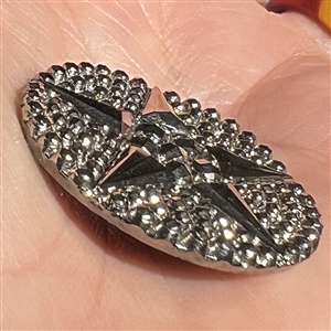 A 19th c. black glass button of a star with silver luster.