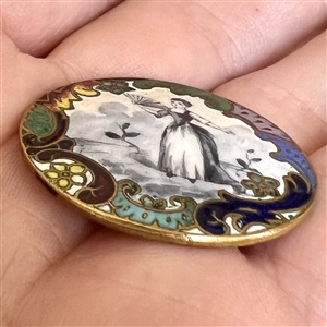 A 19th c. enamel button of woman with a fan.