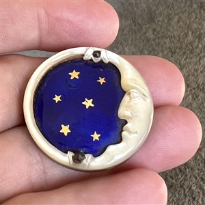 A 19th c. Carved pearl button of “man in the moon with enamel sky and stars.