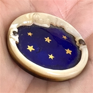 A 19th c. Carved pearl button of “man in the moon with enamel sky and stars.