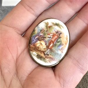 Porcelain oval button of a man and woman done in “Watteau style.