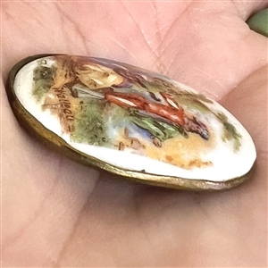 Porcelain oval button of a man and woman done in “Watteau style.
